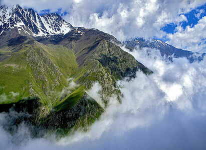 Туман из долины встречается с облаками.  Лето. Кавказ.